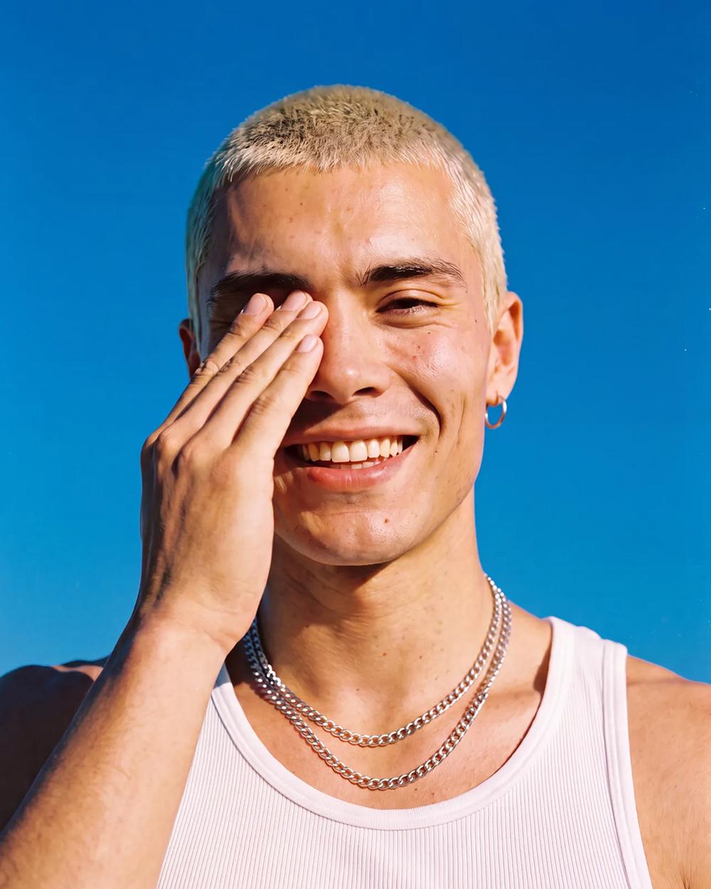 Blonde man against blue sky